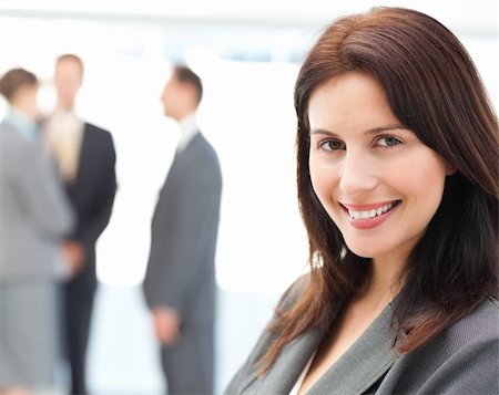 simsearch:400-05746962,k - Charismatic businesswoman posing in front of her team while talking on the background Stock Photo - Budget Royalty-Free & Subscription, Code: 400-04296696