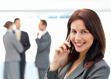 simsearch:400-05746962,k - Cute businesswoman on the phone while her team discussing on the background Stock Photo - Budget Royalty-Free & Subscription, Code: 400-04296699