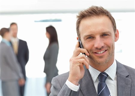 simsearch:400-05746962,k - Happy businessman on the phone while his team working on the background Stock Photo - Budget Royalty-Free & Subscription, Code: 400-04296705