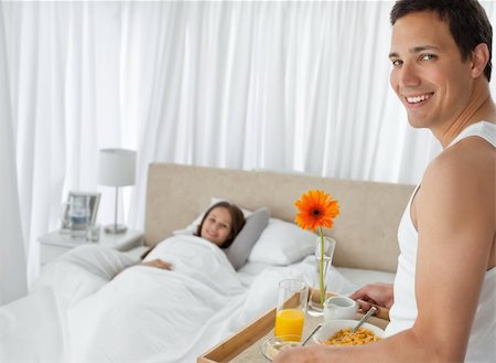 Happy man bringing the breakfast to his girlfriend on the bed at home Stock Photo - Budget Royalty-Free & Subscription, Code: 400-04296876