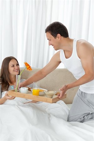 Attentive man bringing the breakfast to his girlfriend on the bed at home Stock Photo - Budget Royalty-Free & Subscription, Code: 400-04296878