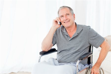 Senior in his wheelchair phoning at home Stock Photo - Budget Royalty-Free & Subscription, Code: 400-04306453