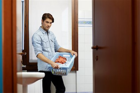 simsearch:400-07902993,k - portrait of adult caucasian man leaning on washing machine and looking at camera with clothes basket. Horizontal shape, side view, copy space Photographie de stock - Aubaine LD & Abonnement, Code: 400-04300664