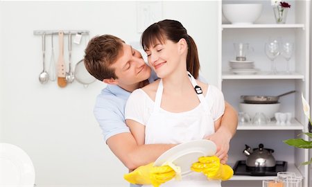 Handsome man hugging his wife in their kitchen Stock Photo - Budget Royalty-Free & Subscription, Code: 400-04300862