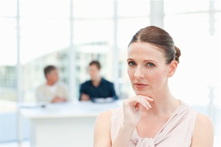 simsearch:400-05746962,k - Serious businesswoman looking at the camera while her coworkers are talking in the office Stock Photo - Budget Royalty-Free & Subscription, Code: 400-04300982