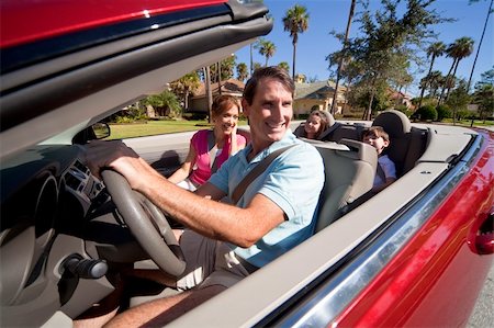 Man and woman parents and two children having fun driving in a red convertible car in sunshine Stock Photo - Budget Royalty-Free & Subscription, Code: 400-04310602