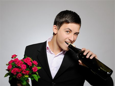 simsearch:400-04739802,k - Handsome romantic young man holding rose flower and vine bottle  prepared for a date. gray background Stock Photo - Budget Royalty-Free & Subscription, Code: 400-04313881