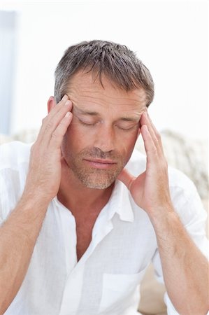 simsearch:400-05388090,k - Man having a headache at home Stock Photo - Budget Royalty-Free & Subscription, Code: 400-04324589