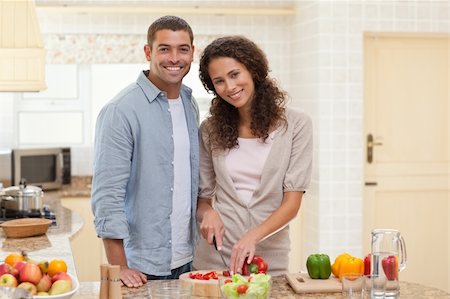 simsearch:400-05744780,k - Couple cooking and looking at the camera in the kitchen Stock Photo - Budget Royalty-Free & Subscription, Code: 400-04325202