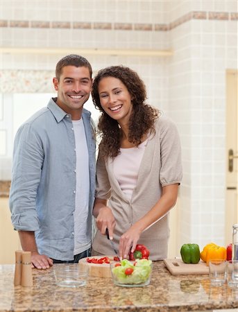 simsearch:400-05744780,k - Couple cooking and looking at the camera in the kitchen Stock Photo - Budget Royalty-Free & Subscription, Code: 400-04325203