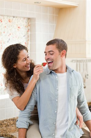 simsearch:400-05744780,k - Lovers eating a strawberry in their kitchen at home Stock Photo - Budget Royalty-Free & Subscription, Code: 400-04325697