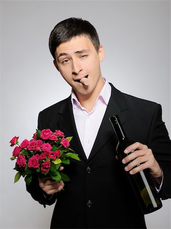 simsearch:400-04739802,k - Handsome romantic young man holding rose flower and vine bottle  prepared for a date. gray background Stock Photo - Budget Royalty-Free & Subscription, Code: 400-04326114