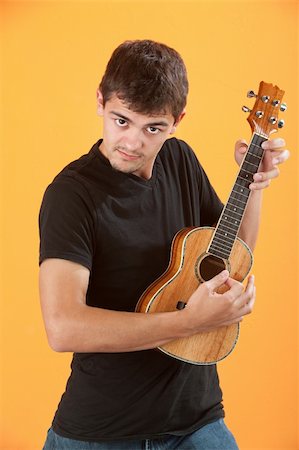Serious Latino teen ukulele player on an orange background Stock Photo - Budget Royalty-Free & Subscription, Code: 400-04328159