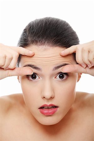 Woman checking her wrinkles on her forehead - isolated on white Stock Photo - Budget Royalty-Free & Subscription, Code: 400-04334882