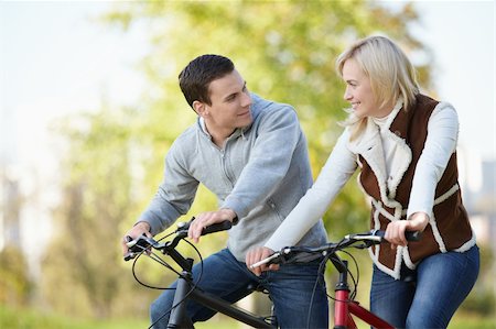 simsearch:400-05755734,k - Attractive couple on bicycles looking at each other Photographie de stock - Aubaine LD & Abonnement, Code: 400-04336536