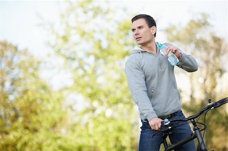 simsearch:400-05755734,k - Young attractive man on a bicycle drink water Photographie de stock - Aubaine LD & Abonnement, Code: 400-04336555