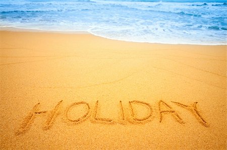 summer text message - "Holiday" written in the sand on the beach blue waves in the background Foto de stock - Super Valor sin royalties y Suscripción, Código: 400-04337214
