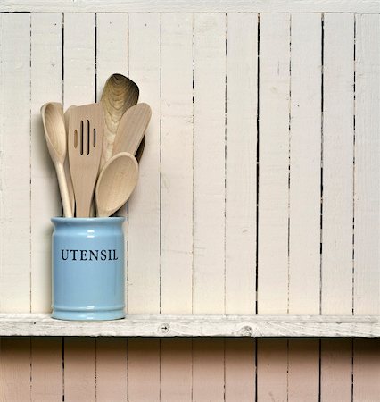 Kitchen cooking utensils; wooden spatulas etc in jar on shelf in front of rustic wall; wall allows good copy-space Stock Photo - Budget Royalty-Free & Subscription, Code: 400-04339030