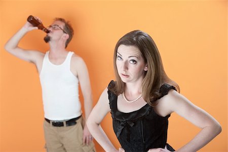 simsearch:400-06396543,k - Unhappy Caucasian wife with alcoholic husband on orange background Stock Photo - Budget Royalty-Free & Subscription, Code: 400-04332666