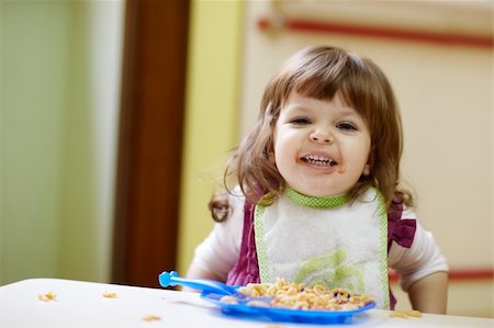 caucasian female preschooler eating pasta and smiling at camera. Horizontal shape, waist up, front view Foto de stock - Super Valor sin royalties y Suscripción, Código: 400-04344271