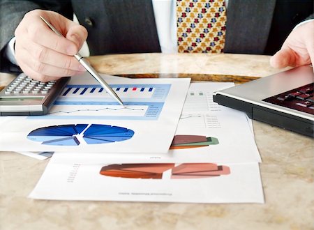 Close-up of male hands holding pen over financial  charts Stock Photo - Budget Royalty-Free & Subscription, Code: 400-04344360