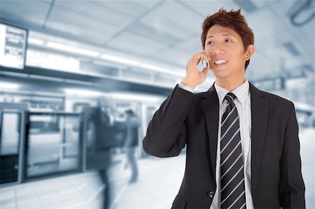 Business man using cellphone when waiting in station. Stock Photo - Budget Royalty-Free & Subscription, Code: 400-04347590