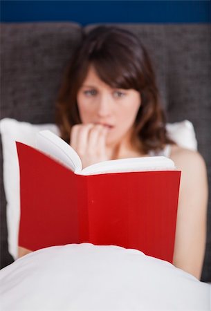 Young woman reading a terror storie with a terrified expression Stock Photo - Budget Royalty-Free & Subscription, Code: 400-04347951