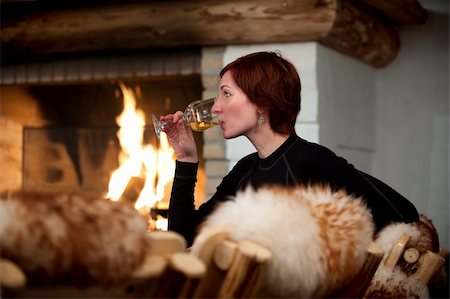 beautiful young woman relaxing and drinking wine in a cozy house with fireplace Stock Photo - Budget Royalty-Free & Subscription, Code: 400-04349356