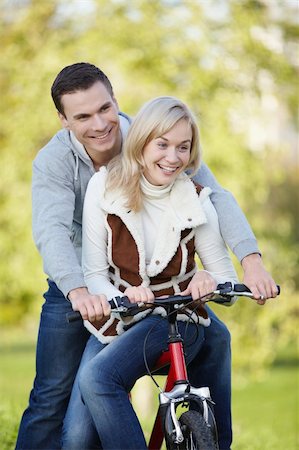 simsearch:400-05755734,k - Young couple rides a bicycle in the park Photographie de stock - Aubaine LD & Abonnement, Code: 400-04340943