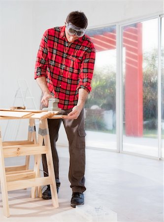 electric sander - A man in a home interior sanding wood with an electric hand sander Stock Photo - Budget Royalty-Free & Subscription, Code: 400-04356279