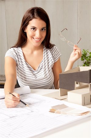 A young female architect at a desk with blueprints and model house Stock Photo - Budget Royalty-Free & Subscription, Code: 400-04356284