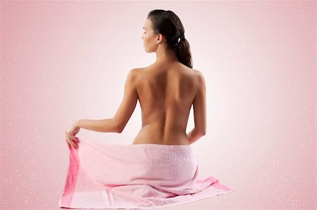 simsearch:400-05322963,k - naked brunette showing her back shoulder and covering her body with a pink towel Stock Photo - Budget Royalty-Free & Subscription, Code: 400-04359884
