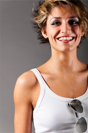 simsearch:400-04325969,k - smiling woman in white tank top and jeans on gray background Foto de stock - Super Valor sin royalties y Suscripción, Código: 400-04361213