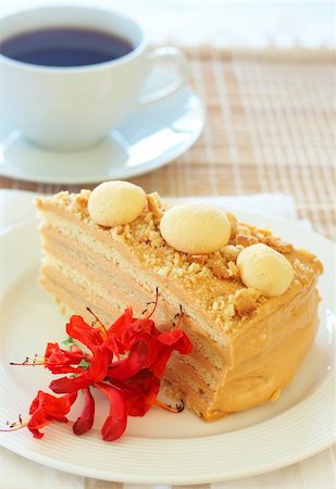 simsearch:400-04764403,k - Slice of caramel Medovik cake made of honey and caramel cream, decorated with flowers with a cup of coffee Stock Photo - Budget Royalty-Free & Subscription, Code: 400-04376795