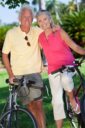 Happy senior man and woman couple together cycling on bicycles outside in a sunny green park Stock Photo - Budget Royalty-Free & Subscription, Code: 400-04373202