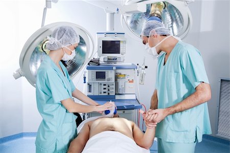 Surgeons operating on patient in an operating theatre Stock Photo - Budget Royalty-Free & Subscription, Code: 400-04386463