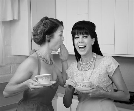 Caucasian woman whispers joke to friend in her kitchen Stock Photo - Budget Royalty-Free & Subscription, Code: 400-04380571