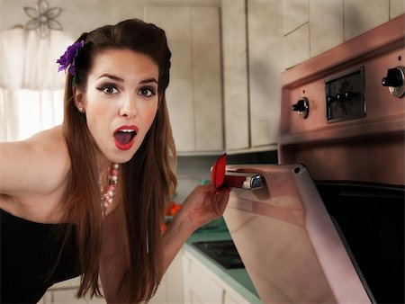 Surprised beautiful Caucasian housewife in kitchen checks her oven Stock Photo - Budget Royalty-Free & Subscription, Code: 400-04380611