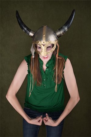 female flexing biceps - Tough-looking woman in Viking helmet flexes her biceps Stock Photo - Budget Royalty-Free & Subscription, Code: 400-04382015