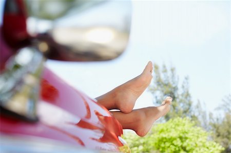 young adult woman relaxing with feet out of convertible red car. Horizontal shape, side view, copy space Photographie de stock - Aubaine LD & Abonnement, Code: 400-04394205