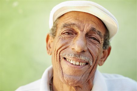 simsearch:400-06142278,k - portrait of senior hispanic man with white hat looking at camera against green wall and smiling. Horizontal shape, copy space Stock Photo - Budget Royalty-Free & Subscription, Code: 400-04404909