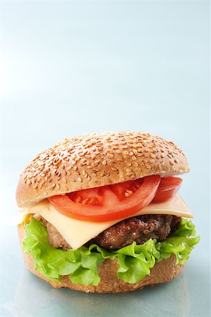 simsearch:400-06090558,k - Cheeseburger with tomatoes and lettuce on grey background Stock Photo - Budget Royalty-Free & Subscription, Code: 400-04406562