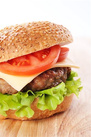 simsearch:400-06090558,k - Cheeseburger with tomatoes and lettuce on a wooden table Stock Photo - Budget Royalty-Free & Subscription, Code: 400-04406563