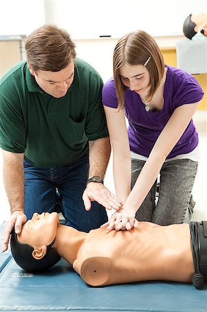 simsearch:400-07411030,k - Teen girl practicing CPR on a mannequin, with her teacher's help. Stock Photo - Budget Royalty-Free & Subscription, Code: 400-04406953