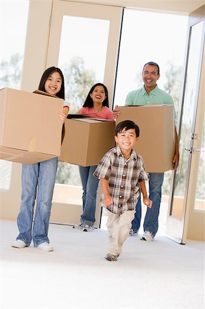 filipina mother daughter - Family with boxes moving into new home smiling Photographie de stock - Aubaine LD & Abonnement, Code: 400-04401414