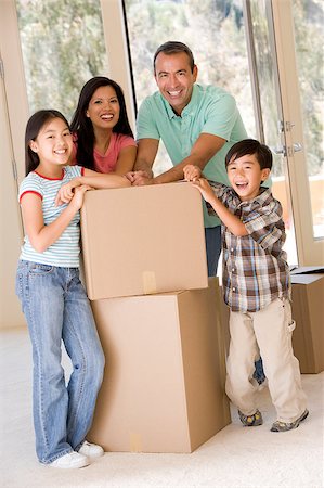 filipina mother daughter - Family with boxes in new home smiling Photographie de stock - Aubaine LD & Abonnement, Code: 400-04401415