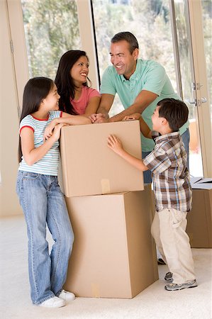 filipina mother daughter - Family with boxes in new home smiling Photographie de stock - Aubaine LD & Abonnement, Code: 400-04401416