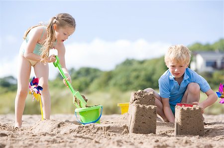 Brother and sister at beach making sand castles Stock Photo - Budget Royalty-Free & Subscription, Code: 400-04402128