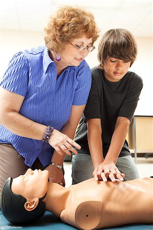 simsearch:400-07411030,k - Teacher helping a teenage boy learn how to perform CPR. Stock Photo - Budget Royalty-Free & Subscription, Code: 400-04414097