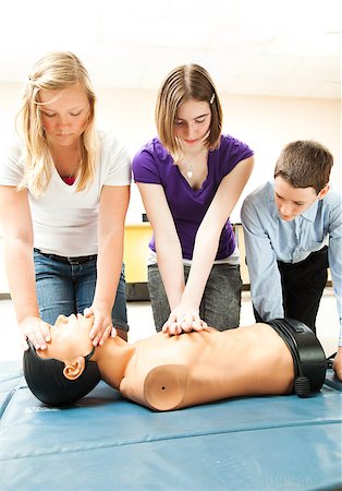 simsearch:400-07411030,k - Two teenage girls and a boy practicing CPR life saving in school. Stock Photo - Budget Royalty-Free & Subscription, Code: 400-04414102